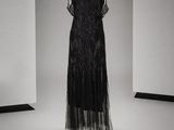 une robe noire posée sur un mannequin dans une pièce vide