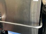 a stainless steel dishwasher sitting on a metal rack