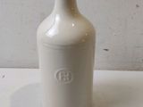 a white vase sitting on a table with a white wall in the background