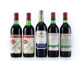 four bottles of wine are lined up on a white surface