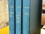 three blue books sitting on top of a yellow table next to each other