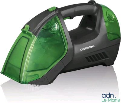 aspirateur à main vert et noir posé sur une surface blanche
