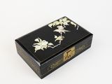 an image of a black and gold box with flowers on it