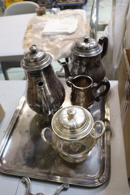 trois théières en argent posées sur un plateau, lui-même posé sur une table