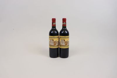 deux bouteilles de vin posées sur une table blanche
