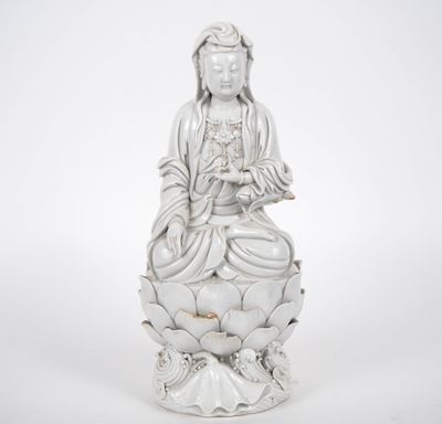 une statue blanche représentant une femme assise sur une fleur de lotus