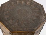an ornate wooden table with metal decorations on top of it