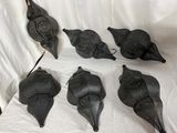 six oiseaux noirs sont posés sur un drap blanc posé sur une surface blanche
