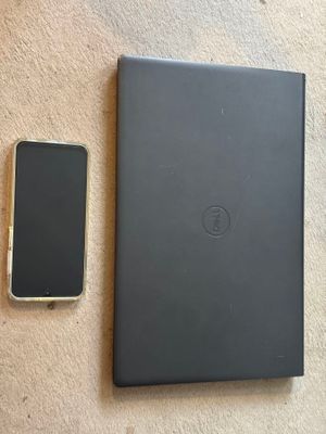 un téléphone portable à côté d'un ordinateur portable et d'un cahier posé par terre