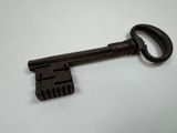 an old key is sitting on top of a white table