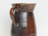 a brown vase with a handle on a white background