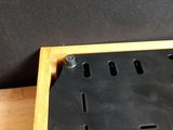 a black board with holes in it sitting on a wooden table