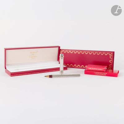 une boîte ouverte contenant un stylo et un crayon, posée sur une surface blanche