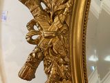 a mirror with a gold leaf decoration on it
