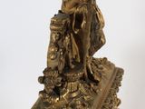 a gold clock with a statue on top of it