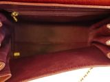 the inside of a brown purse with a chain hanging from it