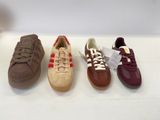 four pairs of shoes are lined up on a white surface