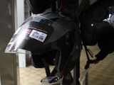 many helmets hanging on a rack in a store