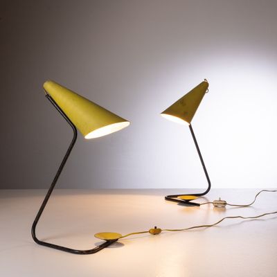 deux lampes jaunes posées sur une table blanche, avec un mur blanc en arrière-plan