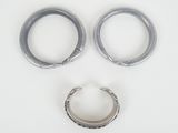 pair of silver hoop earrings and a silver ring on a white surface