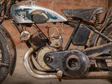 a old motorcycle that is parked in front of a brick wall