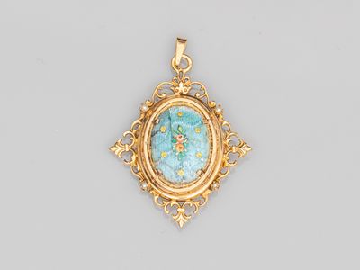 un pendentif en or orné d'une pierre turquoise au centre