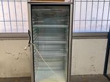 une photo d'un réfrigérateur dans un entrepôt, la porte ouverte