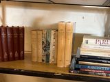 de nombreux livres sur une étagère sur laquelle sont posées une paire de ciseaux