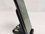a close up of a cell phone on a stand on a table