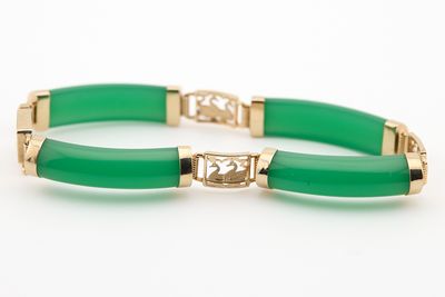 un gros plan d'un bracelet vert posé sur une surface blanche