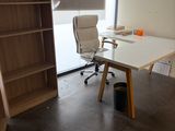 un bureau avec une chaise et une bibliothèque dans un coin