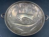 a silver plate with a boat on it on a table