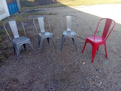 four chairs sitting in a circle in the dirt