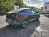 the rear end of a grey car parked on the side of the road