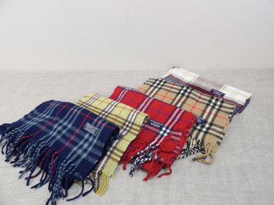 four different colors of scarves laid out on a white surface