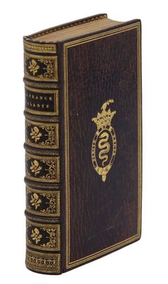 un vieux livre orné d'un emblème doré sur la couverture