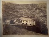 a picture of an old photo of a farm in the mountains