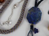 many different necklaces and bracelets on a table