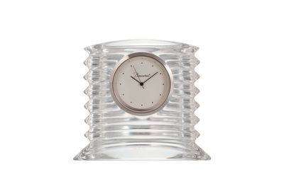 une photo d'une horloge transparente posée sur une table en verre