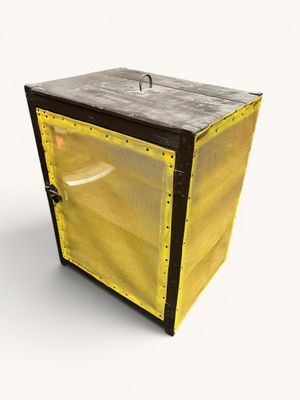 une boîte jaune avec un couvercle noir posée sur une surface blanche