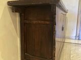 a small wooden cabinet in the corner of a room