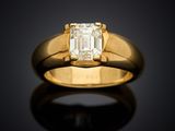 a yellow gold ring with an emerald stone in the center