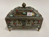 une boîte en argent ornée de motifs rouges et verts