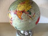 un petit globe terrestre posé sur un socle et sur lequel figure une carte