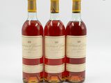 trois bouteilles de vin posées les unes à côté des autres sur une surface blanche