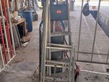 a picture of a ladder in a garage with a lot of tools