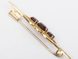 a close up of a gold and garnet stone broochle