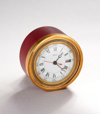 une horloge rouge et dorée avec des chiffres romains