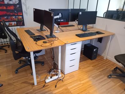 un bureau équipé de deux écrans et d'un clavier