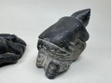 pair of black and white stone sculptures of a hand and a shell